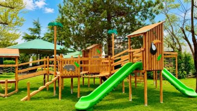 Natural wooden playground with green slides — Elysee