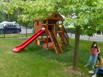 Wooden playhouse with a red slide — Elysee