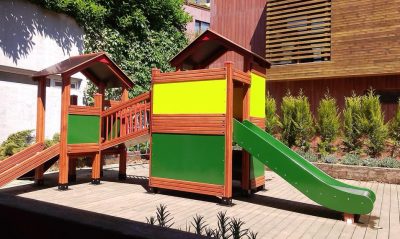 Natural wooden playground with green slides — Elysee